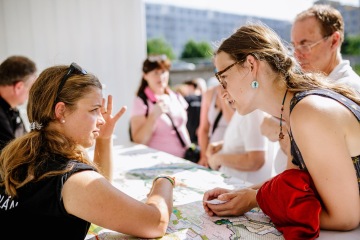 Obyvatelka městské čtvrtě sděluje nad mapou města svůj názor na nové urbanistické plány. Zdroj: IPR Praha